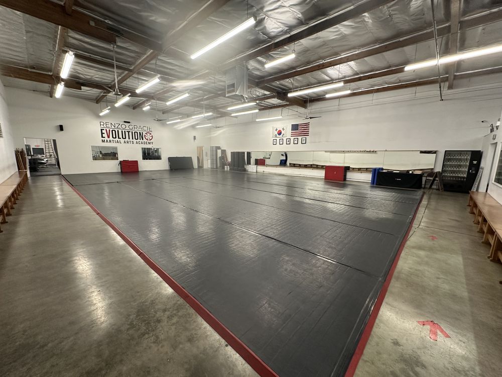 Main training floor at Renzo Gracie Evolution in Chatsworth with padded walls and bench seating