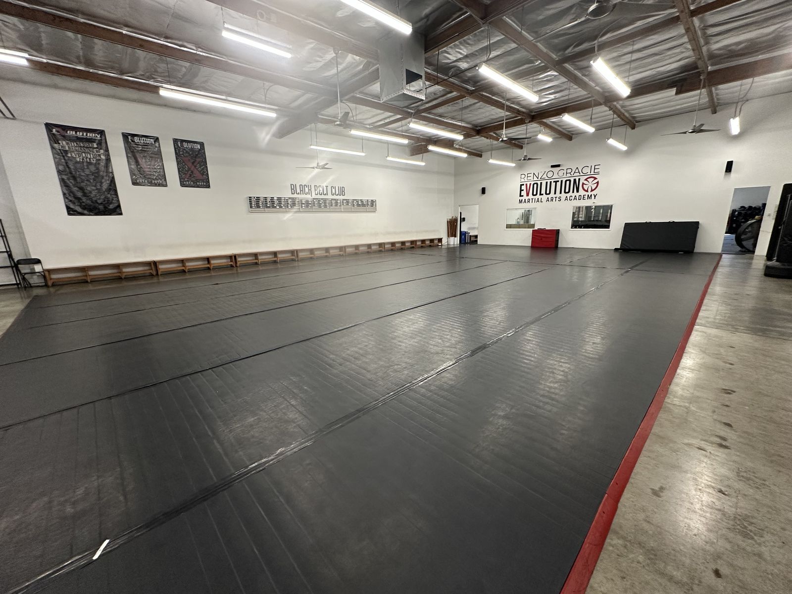 Wide view of the main mat and spectator bench at Renzo Gracie Evolution in Chatsworth