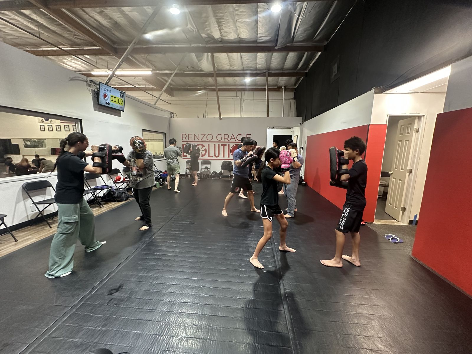Adult Muay Thai class working Thai pads in pairs on the main mat at Renzo Gracie Evolution in Chatsworth